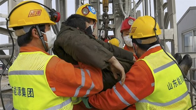 Záchranáři vyzvedávají jednoho z horníků, kteří po výbuchu ve zlatém dole v provincii Šan-tung zůstali uvězněni v podzemí. (24. ledna 2021)
