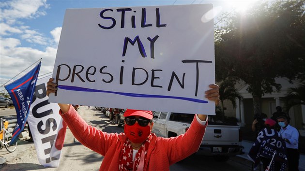 Fanoušek odcházejícího amerického prezidenta Donalda Trumpa drží transparent ve West Palm Beach na Floridě. (20. ledna 2021)