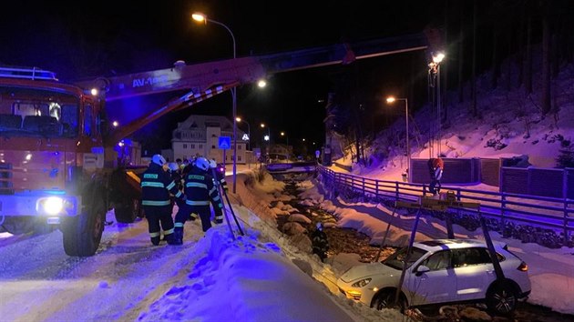 Hasii vytahovali havarovan auto z koryta py v Peci pod Snkou, jejich technika na to vak nestaila (24. 1. 2021).