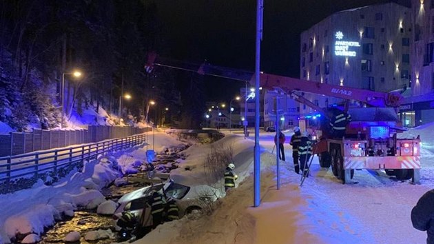 Hasii vytahovali havarovan auto z koryta py v Peci pod Snkou, jejich technika na to vak nestaila (24. 1. 2021).