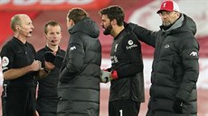 Anglický sudí Mike Dean elí výitkám liverpoolského brankáe Alissona, kterého...