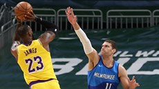 LeBron James z Los Angeles Lakers střílí přes bránícího Brooka Lopeho z...