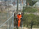 Amerití vojáci vedou trestance ve vznici Guantánamo. (1. bezna 2002)