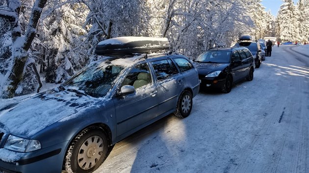 Lidé svoje auta při návštěvě hor parkovali podél silnice I/11. Zasáhnout musela policie. (31. ledna 2021)