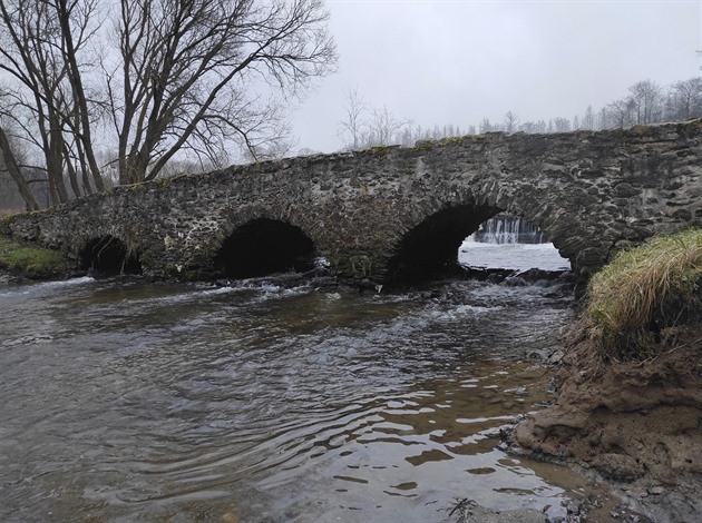 Pokozený jez, voda a balvany ohroují památkov chránný stedovký most U...