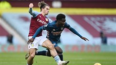 Jack Grealish (vlevo) z Aston Villy a Bukayo Saka z Arsenalu bojují o balon.