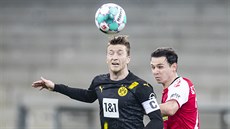 Kapitán Dortmundu Marco Reus (vlevo) hlavikuje balon v zápase proti Freiburgu.