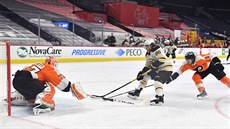 Brian Elliott v brance Philadelphie zasahuje proti Davidu Pastrákovi z Bostonu.