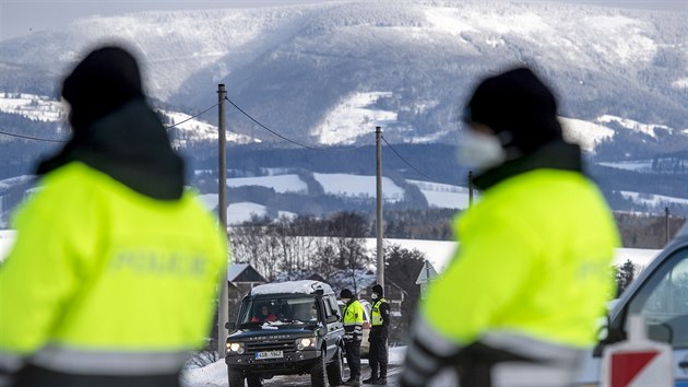 Policisté kontrolují řidiče automobilu u obce Dolní Branná na hranici okresů Trutnov a Semily. (13. února 2021)