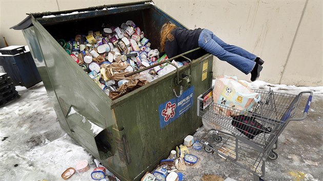 Žena v texaském Arlingtonu vybírá jídlo z popelnice před supermarketem, jenž musel mražené potraviny vyhodit kvůli výpadku elektřiny. (17. února 2021)