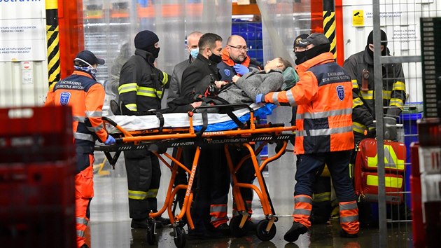 Zdravotníci odváží zraněnou prodavačku, kterou v slovenském městě Kežmarok zajmul únosce. Policie ho zadržela. (18. února 2021)