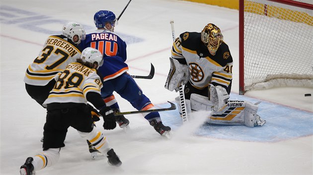 Jean-Gabriel Pageau z New York Islanders překonává brankáře Bostonu Tuukku Raska, Patrice Bergeron a David Pastrňák přijeli na pomoc pozdě.