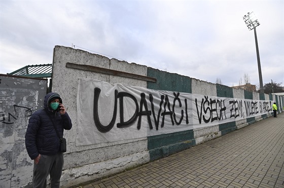 Nápis na zdi, zpoza které fanouci Bohemians ze taflí a ebík díve...