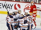 Branká Calgary David Rittich smutní, hokejisté Edmontonu slaví gól.