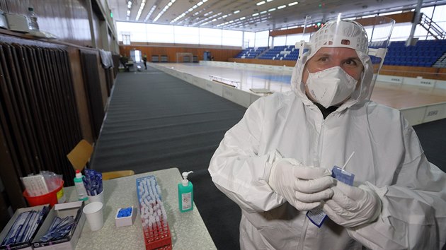 Antigenní testování se nově přesunulo z chebské nemocnice do sportovní haly. Lidé za halou čekají na výsledky, dodržují rozestupy. (22. února 2021)