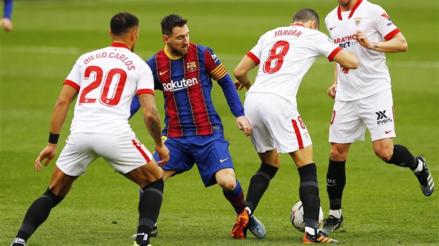 Lionel Messi (druhý zleva) bojuje o balon s Joanem Jordánem ze Sevilly.