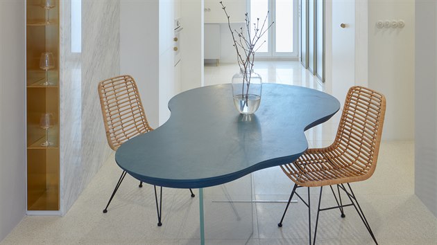Deska stolu má organický tvar, je vyrobena z několika vrstev překližky. Podnoží je ze skla, díky tomu stůl vypadá, jako by levitoval.