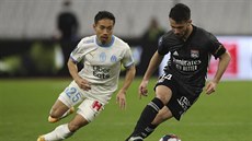 Léo Dubois (vpravo) z Lyonu vede balon, napadá ho Júto Nagatomo z Marseille.