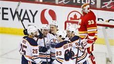 Branká Calgary David Rittich smutní, hokejisté Edmontonu slaví gól.