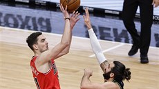 Tomá� Satoranský (vlevo) z Chicaga st�ílí p�es Rickyho Rubia z Minnesoty.