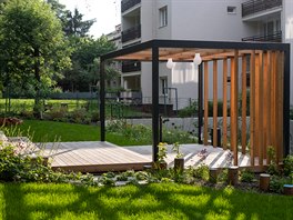 Srdcem společné zahrady je dřevěná terasa s několika výškovými stupni, které...