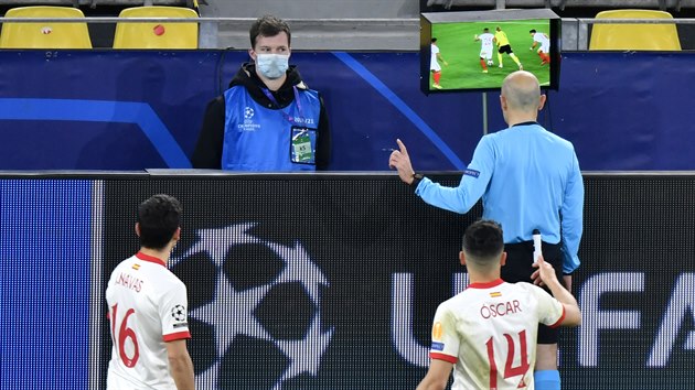 Rozhodčí Cüneyt Cakir pozoruje video při zápase Dortmund - Sevilla.