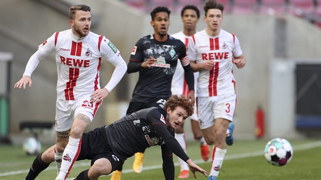 Joshua Sargent z Werderu Brémy padá v utkání proti Kolínu. Vzadu přihlíží jeho spoluhráč Theo Gebre Selassie.