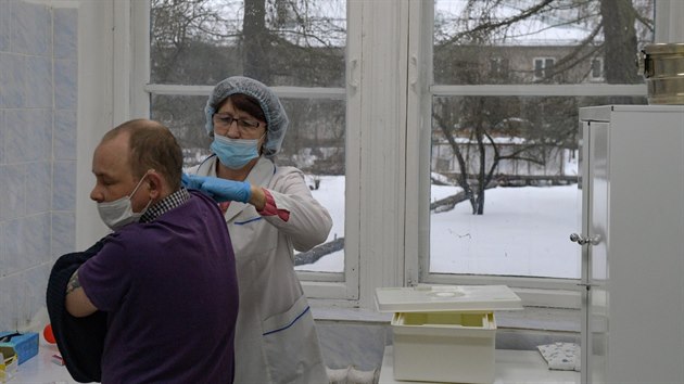 Zdravotnice očkuje muže vakcínou Sputnik V v ruské obci Všeli. (25. února 2021)