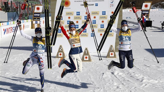 Vítězná Therese Johaugová (uprostřed), druhá Frida Karlssonová (vlevo a třetí Ebba Anderssonová slaví po volné desítce na mistrovství světa v Oberstdorfu.