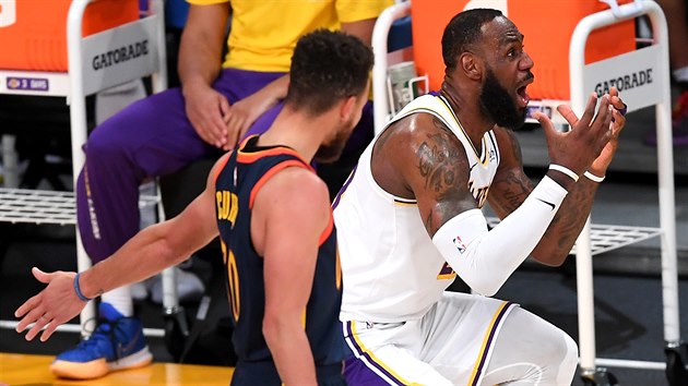 LeBron James (vpravo) z LA Lakers se zlobí na rozhodčího, Stephen Curry z Golden State mu cosi vysvětluje.