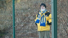 Fanoušek Varnsdorfu sleduje zápas přes plot.