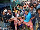 Lidé nesou enu postelenou pi protestech v Barm. Pi nedlních protestech v...