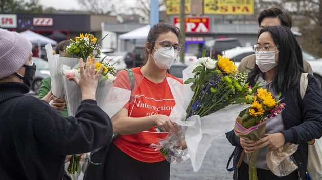 Lidé pokládají kytky k masážním salonům v Atlantě, kde útočník zabil osm lidí, převážně asijské ženy. (17. března 2021)