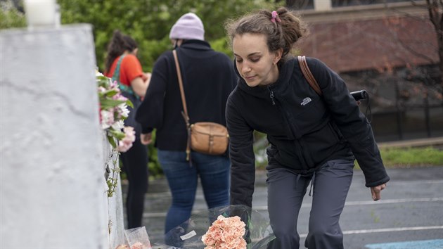 Lidé pokládají kytky k masážním salonům v Atlantě, kde útočník zabil osm lidí, převážně asijské ženy. (17. března 2021)