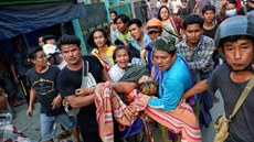 Lidé nesou enu postelenou pi protestech v Barm. Pi nedlních protestech v...