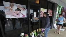 Lidé pokládají kytky k masáním salonm v Atlant, kde útoník zabil osm lidí,...