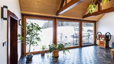 Velké formáty oken v dřevěných rámech spojily interiér obytné místnosti s...