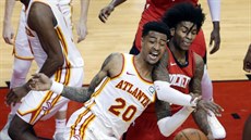 John Collins (20) z Atlanty a Kevin Porter Jr. z Houstonu bojují o mí.