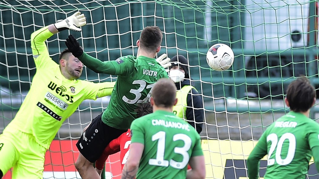 Brn�nský branká� Martin Berkovec inkasuje  od p�íbramského Radka Voltra.