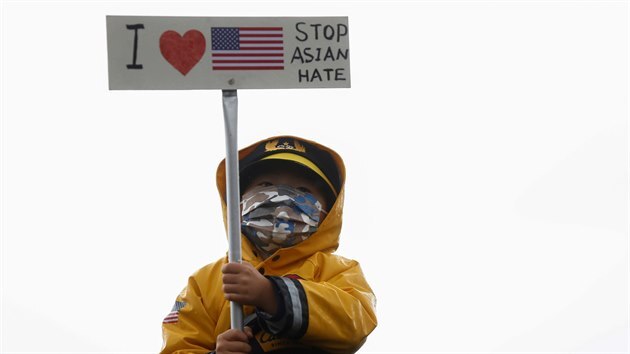 Dítě drží v rukách transparent s hesly „Miluju Ameriku“ a „Zastavte nenávist vůči Asiatům“ při rotestech v americké Atlantě. (21. března)