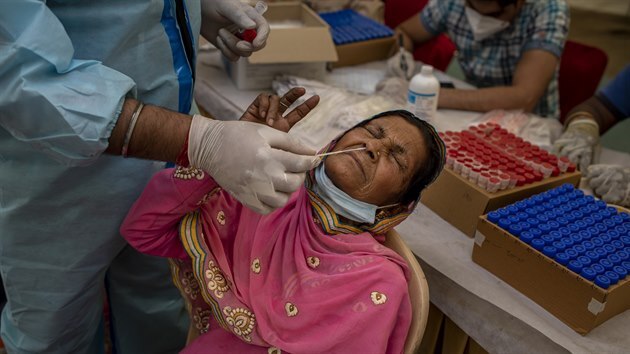 Zdravotník provádí test na koronavirus v centru na autobusovém terminálu v Novém Dillí v Indii. (24. března 2021)