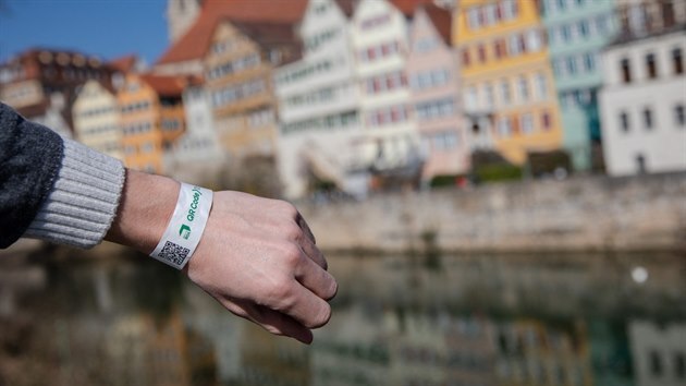 Muž ukazuje náramek s QR kódem, který po oskenování ukáže výsledky testu na koronavirus. Pokud budou negativní, obdrží takzvanou denní vstupenku. S tou lze v německém Tübingenu jít do kaváren, obchodů či kina. (24. března 2021)