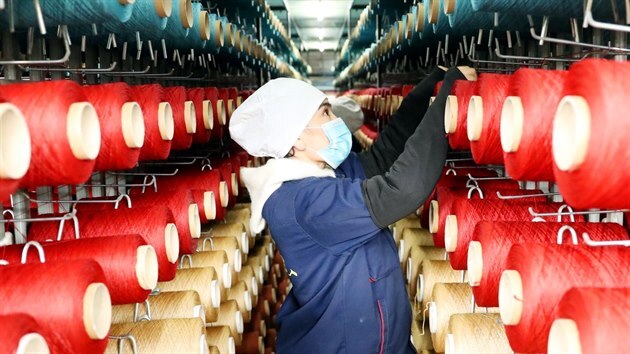 Místní pracovníci, kteří pracují ve výrobní linkách, mají plné ruce práce s výrobou koberců ve městě Urumči v severozápadní Číně s Ujgurskou autonomní oblastí Sin Tiang (18. listopadu 2020).