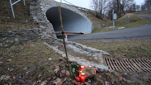 Na místě tragické nehody stojí dřevěný křížek a hoří svíčky.