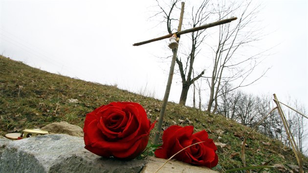 Květiny a provizorní křížek z větviček, který byl po úmrtí ženy vztyčen na místě nehody u tunelu.