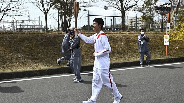 Japanese high school student Asato Owada carries an Olympic Torch during the...