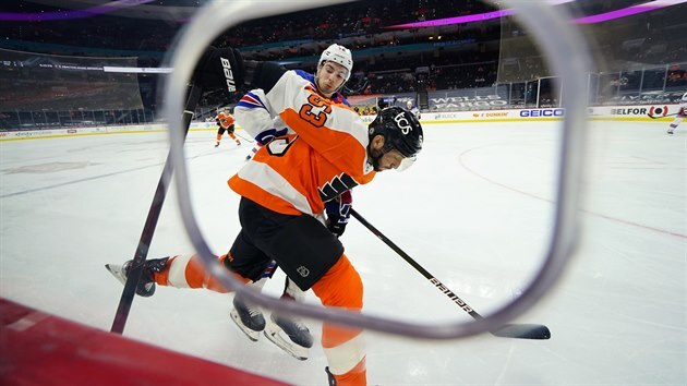 Filip Chytil (vzadu) z New York Rangers v souboji s  Shaynem Gostisbeherem z Philadelphie.