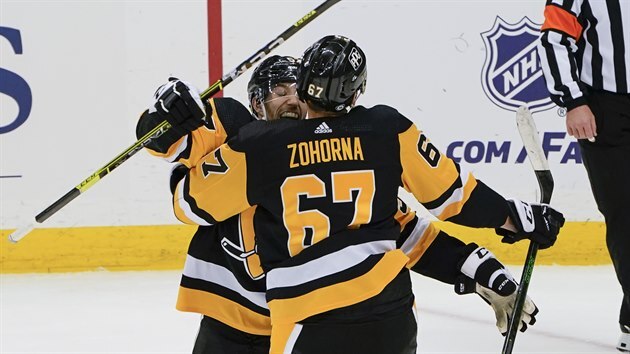 Radim Zohorna (zády) z Pittsburghu se raduje se spoluhráčem Frederickem Gaudreauem ze svého prvního gólu v NHL.