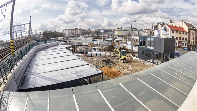 Na volné ploše u bočního vstupu na hlavní vlakové nádraží v Plzni dělníci budují kontejnerové městečko, to zde vyroste do konce letošního dubna. (19. 3. 2021)