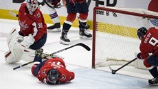 Obránce Washingtonu Dmitrij Orlov (vpravo) zastavuje puk na brankové �á�e v...